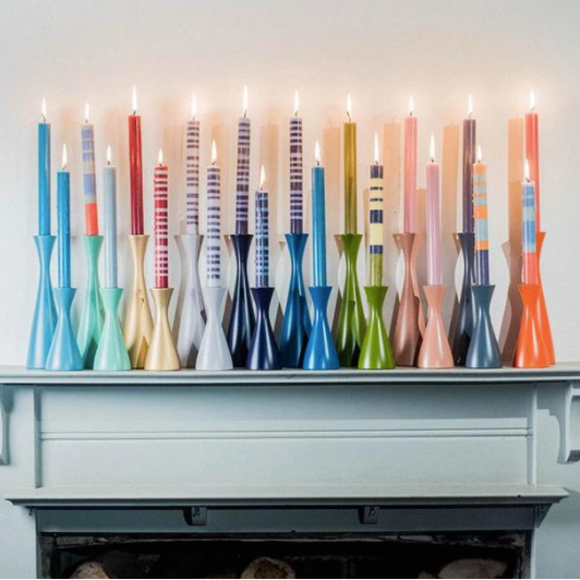 collection of colorful candle holders on mantle